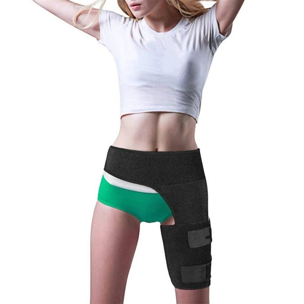 Woman wearing black hip brace for sciatica pain relief with compression wrap on thigh and waist